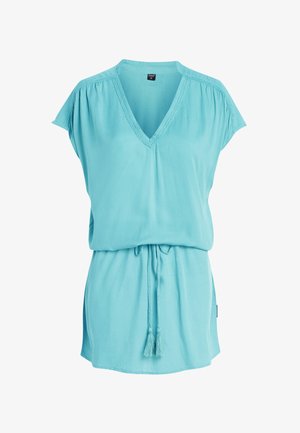 Lys blå kortærmet tunika med V-hals, snøre i taljen og frynse detaljer. Fremstillet af blødt, let stof.