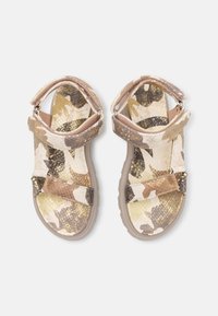 Sandały w kamuflażu z teksturowanego materiału w odcieniach beżu, kremu i złota, z regulowanymi paskami i lekką gumową podeszwą.