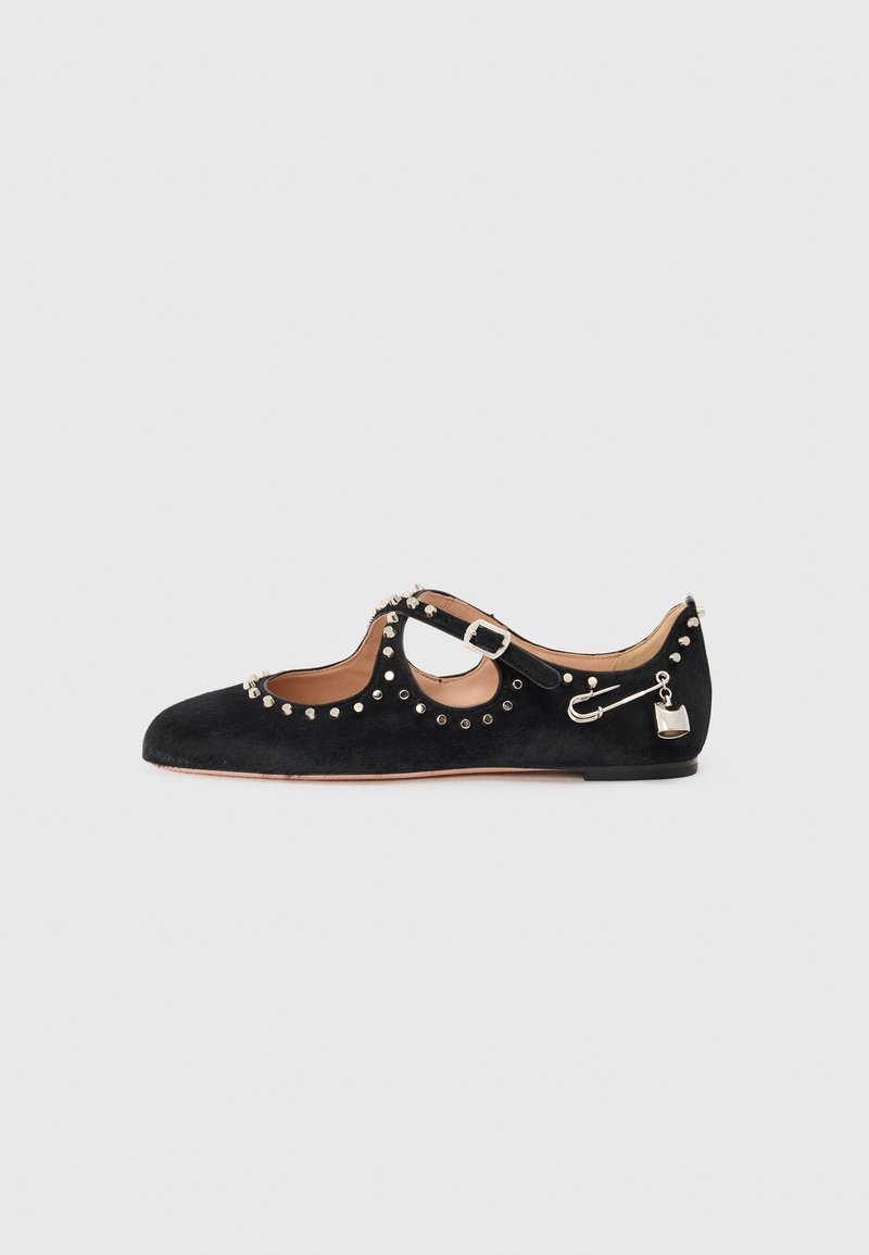 Chaussure plate en daim noir avec un design ajouré, ornée de clous en argent, d'un accent de pin de sécurité et d'un petit détail de cadenas.