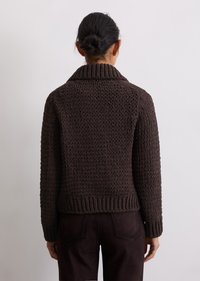Maglione marrone lavorato a maglia con colletto a costine, tessuto testurizzato e orlo aderente. La parte posteriore mostra un design strutturato e maniche lunghe.