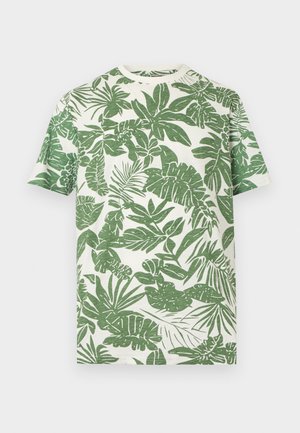 Weißes T-Shirt mit kurzen Ärmeln und einem durchgehenden grünen tropischen Blattmuster, das Palmen- und Monstera-Blätter zeigt.