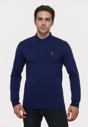 Marineblauwe longsleeve polo gemaakt van soepel materiaal, met een kraag, een drieknoopsluiting en een gouden logo op de borst.