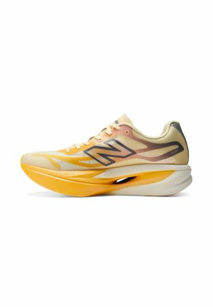 Hellgelber und oranger New Balance Laufschuh mit dicker, gepolsterter Sohle und großem "N"-Logo an der Seite.