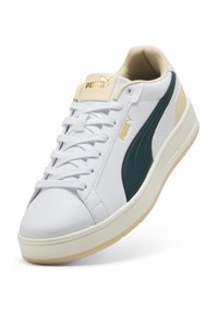 Hvide syntetiske sneakers med en grøn side-stribe, beige accenter, flade snørebånd og et guld-logo på tungen. Tekstureret overdel og gummisål.