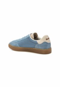 Zapatillas de gamuza y cuero en azul claro con una suela de goma marrón, acentos en colores neutros y puntera redonda. Presenta detalles cosidos y un logotipo en el talón.