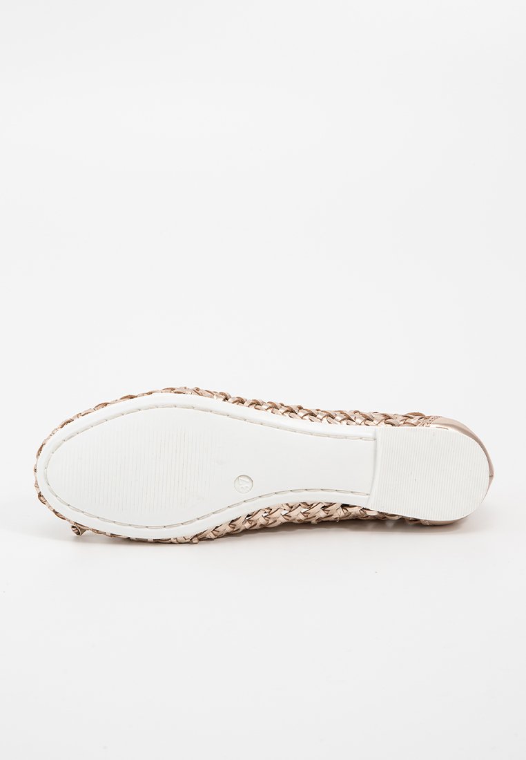 Chaussure plate avec un-dessus en simili cuir tressé de couleur rose doré, semelle en caoutchouc blanche et bout rond. Motif texturé le long de la semelle.