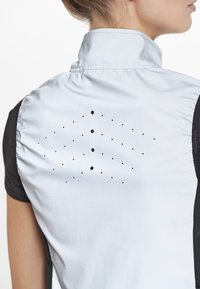 Prestatie shirt met een lichtblauwe ademende rug en zwarte korte mouwen, textielmateriaal en een patroon van kleine geperforeerde gaatjes voor ventilatie.