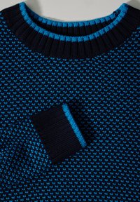 Suéter de punto azul marino con un patrón texturizado, con un cuello y puños de canalé en un azul más claro, que resalta los colores contrastantes.