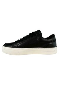 Sneaker in pelle nera con superficie liscia, suola in gomma bianca, punta rotonda e lacci neri. Dettagli cuciti sui lati e sul retro.
