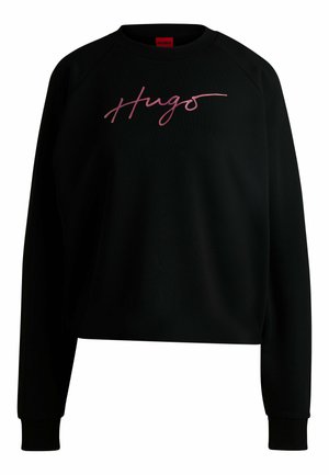 Black sweatshirt with a crew neck and raglan sleeves. Features a pink cursive "Hugo" logo on the front. Made of a soft, textured fabric.