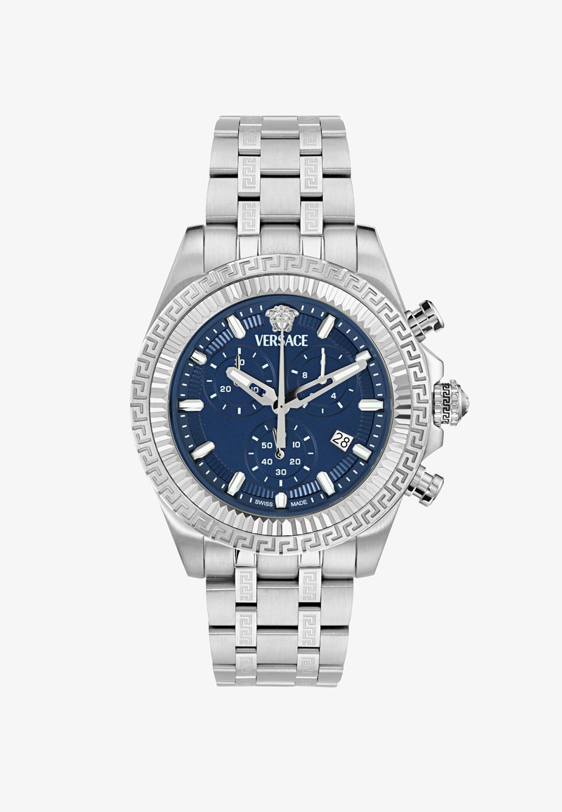 Srebrny zegarek ze stali nierdzewnej z niebieską tarczą, funkcjami chronografu, teksturowaną lunetą oraz wzorem greckiego klucza na bransolecie. Posiada wyświetlacz daty.