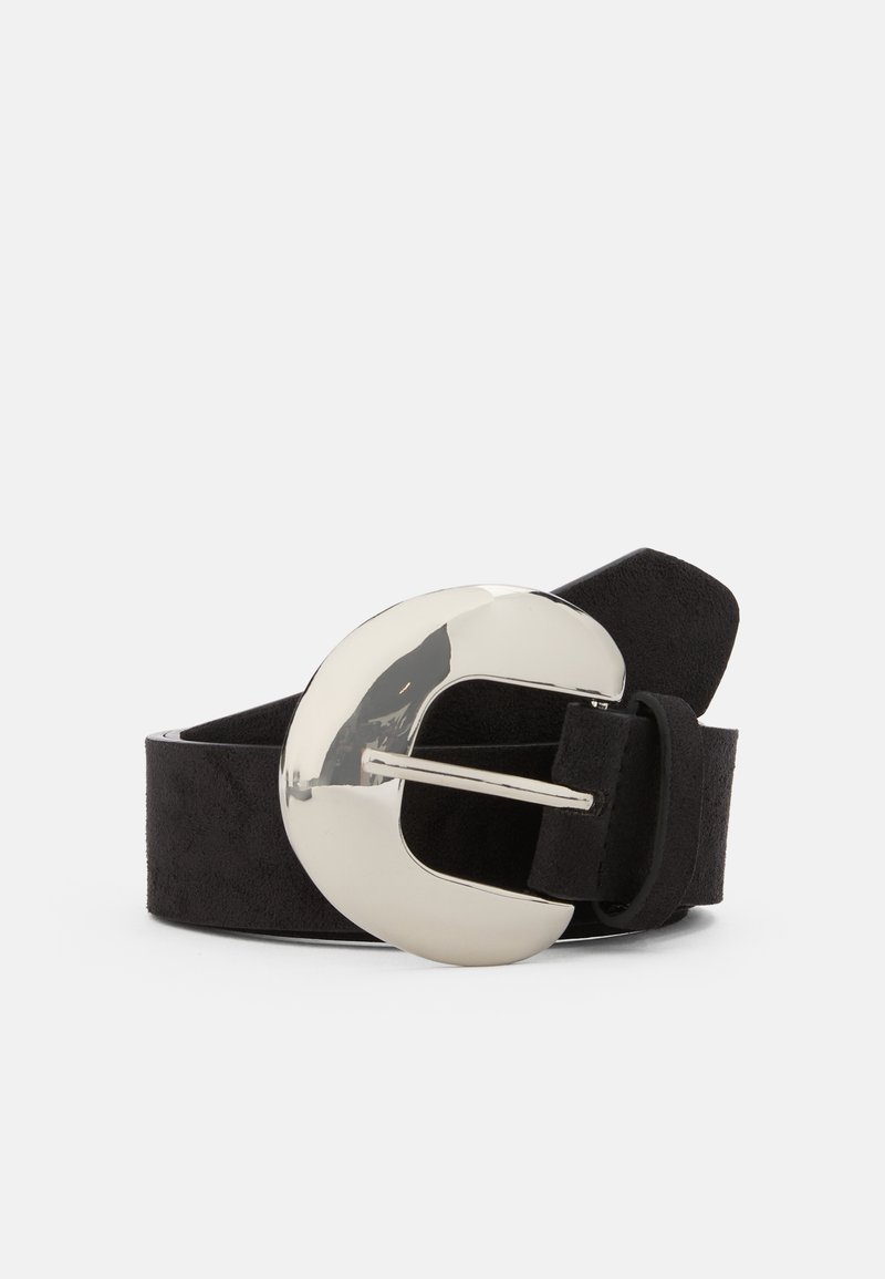Curea din suede negru cu o cataramă circulară mare, argintie și lucioasă. Catarama are un design decupat și un singur cui pentru prindere.