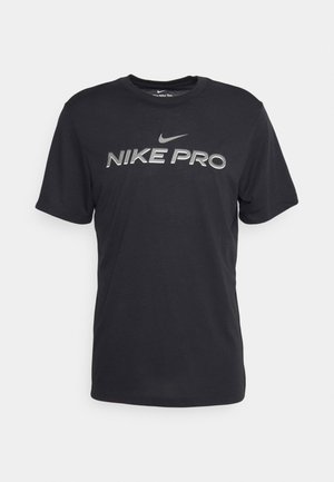 Juodos Nike Pro marškinėliai, pagaminti iš minkštos medžiagos; turi trumpas rankoves, apvalų iškirpimą ir ryškų sidabrinį logotipą krūtinės srityje.