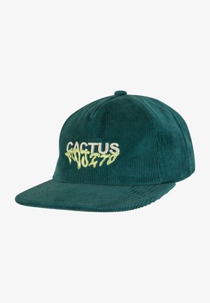 Zaļš korduroja cepure ar plakanu maliņu, ar baltiem un dzelteniem izšūtiem burtiem "CACTUS." Burtiem ir pilienu efekts.