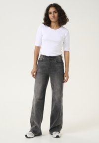 Black, wide-leg jeans with a faded wash, classic five-pocket design, and high waist. Paired with a fitted white t-shirt and sneakers.