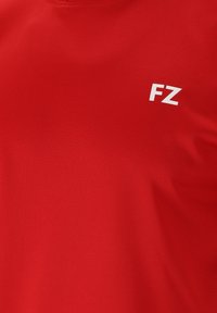 Rød stof med et hvidt "FZ" logo trykt i øverste højre hjørne.