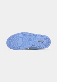Šviesiai mėlyna sportinio bato pado paviršius turi tekstūrinių raštų, apskritų ir linijinių dizainų, su "Nike" logotipu ir tvirta gumos konstrukcija.