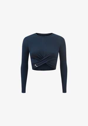 Tamsiai mėlynas ilgomis rankovėmis trumpas viršus, su suktos priekinės dalies dizainu. Pagamintas iš minkštos medžiagos su vientisa tekstūra ir mažo logotipo akcentu ant apačios.