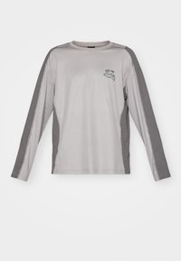 Long-sleeve gray shirt with darker gray side panels and a small black logo on the chest. Made of soft, stretchable fabric.