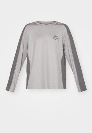 Long-sleeve gray shirt with darker gray side panels and a small black logo on the chest. Made of soft, stretchable fabric.