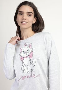 Sudadera gris claro con un dibujo de un gato blanco de dibujos animados con un lazo rosa y "Marie" en cursiva, hecha de un tejido suave y con un corte relajado.