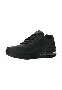 Scarpa sportiva nera con una parte superiore in materiale sintetico liscio, colletto imbottito, motivi testurizzati e un'unità di ammortizzazione ad aria trasparente nella suola.