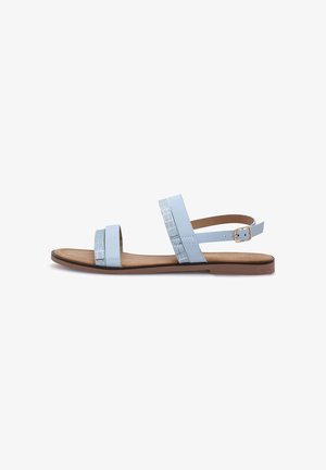 Sandalo piatto azzurro chiaro con due cinturini anteriori, cinturino alla caviglia con fibbia dorata e suola imbottita color cognac su sfondo bianco.