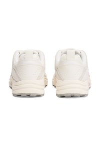 Lyse beige treningssko med mesh-overdel, polstret krage og teksturert hæl. Har en løfletapp og gummiyttersåle for godt feste.