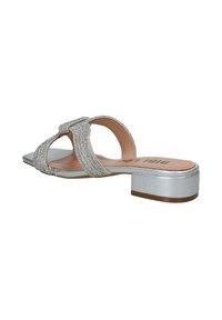 Zilveren slide-sandalen met een textuurriem en metallic accenten, lage blokhak en een zachte, gebogen teenvorm.