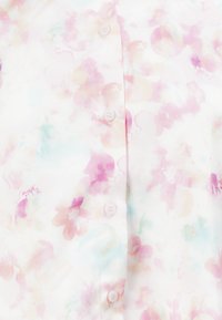 Camicia a maniche corte con bottoni in tessuto morbido e leggero. Presenta motivi floreali in acquerello rosa e azzurro chiaro, con bottoni di un delicato rosa.