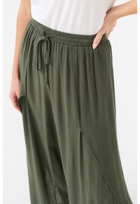 Pantaloni plissettati leggeri verde oliva con cintura elastica e cordoncino regolabile. Texture morbida con tasche laterali.