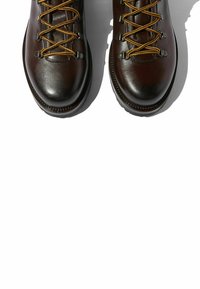 Botas de senderismo de cuero marrón oscuro con herrajes metálicos para los cordones y cordones naranjas. Punta redondeada y suelas de goma duraderas para tracción.