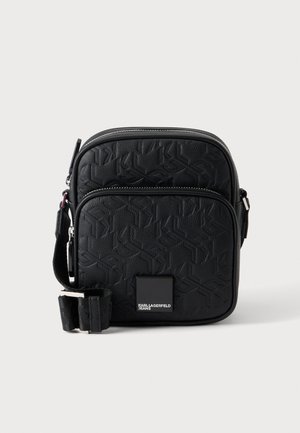 Čierna textúrovaná crossbody taška s reliéfnym vzorom, predným vreckom na zips, nastaviteľným remienkom a logom "Karl Lagerfeld Jeans".