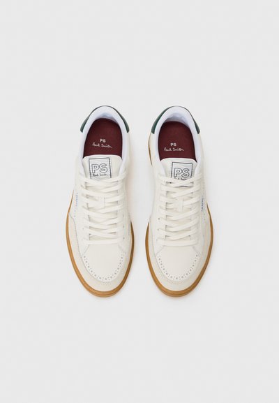 Weiße Ledersneaker mit perforierten Details, runder Spitze, flachen Schnürsenkeln und hellbraunen Gummisohlen. Grüne Akzente an der Ferse.