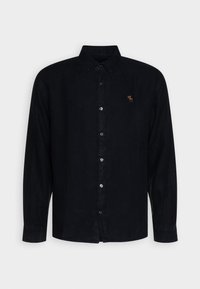 Camisa de botones de manga larga en azul oscuro con una textura especial. Presenta un cuello, cierre frontal con botones y un pequeño logo bordado en el pecho.