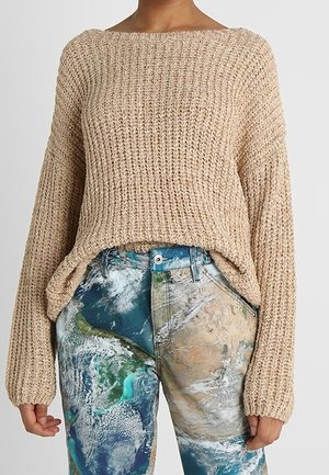 Beige gebreide trui met een brede halslijn, oversized mouwen en een gestructureerd ribpatroon, gecombineerd met multikleurige broeken met een planeet-thema print.
