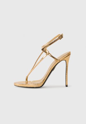 Gouden hoge hak sandaal met een gestructureerd slangenhuidpatroon, dunne banden en een slanke silhouette. Open neus ontwerp met een slanke stiletto hak.