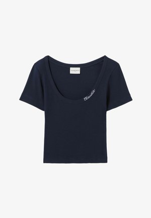 Camiseta de algodón azul marino con textura acanalada, escote amplio, mangas cortas y la palabra "Claudie" bordada en blanco en la parte delantera.