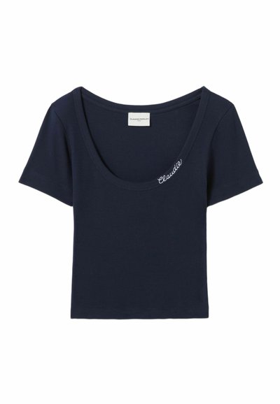 Camiseta de algodón azul marino con textura acanalada, escote amplio, mangas cortas y la palabra "Claudie" bordada en blanco en la parte delantera.