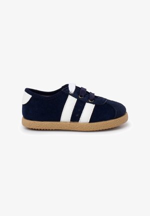 Chaussure en feutre bleu marine avec des rayures blanches, des lacets bicolores et une semelle en caoutchouc texturée de couleur marron clair. Bout rond et design bas.
