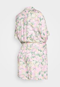 Conjunto de roupa de casa floral em cores pastéis, com mangas curtas, corte largo, cintura elástica, apresentando uma mistura de tons de rosa, amarelo e verde.