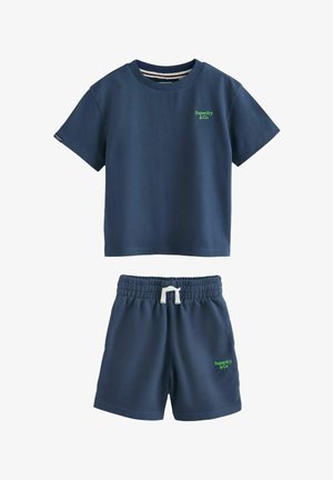 Set pentru copii, format din tricou cu mâneci scurte, albastru închis, și pantaloni scurți cu talie elastică, ambele având mici logo-uri verzi „Superdry & Co”.
