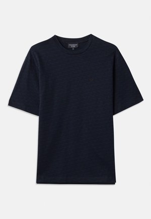 Camiseta de color azul marino con un patrón texturizado, cuello redondo y mangas cortas. Sutil detalle del logo en el pecho, hecha de suave tela de algodón.