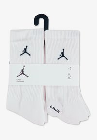 Gewatteerde sneakersokken, wit met zwart Jordan-logo, verkocht per pak van zes. Zachte, geribbelde textuur, voorzien van een hanglabel en een ronde maatsticker.