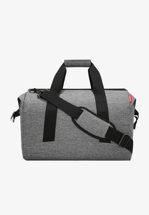Grijze stoffen sporttas met zwarte straps, met een gestructureerde vorm, ritssluiting en een verstelbare schouderband.