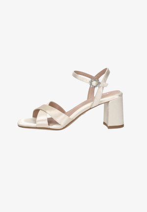 Sandale ouverte en satin ivoire avec talon bloc, brides croisées à l’avant, bride à la cheville et fermeture par boucle décorative.