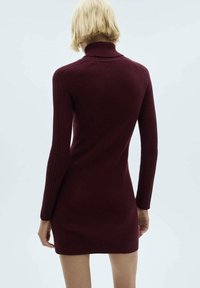 Robe en maille côtelée bordeaux avec un col roulé haut, des manches longues et une silhouette ajustée, présentant une texture lisse et des coutures minimales.