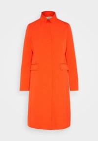 Orange frakke med lange ærmer og høj krave, lige snit, to forlommer og glat tekstur; minimalistisk design uden synlige lukninger.