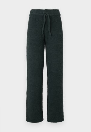 Zwarte, textured loungebroek van zacht, pluizig materiaal. Voorzien van een elastische tailleband met een trekkoord voor een verstelbare pasvorm. Casual rechte pijpen.