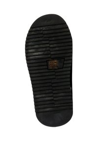 Semelle d'une chaussure noire avec des rainures horizontales et une étiquette rectangulaire indiquant la taille 36, sur un fond blanc.